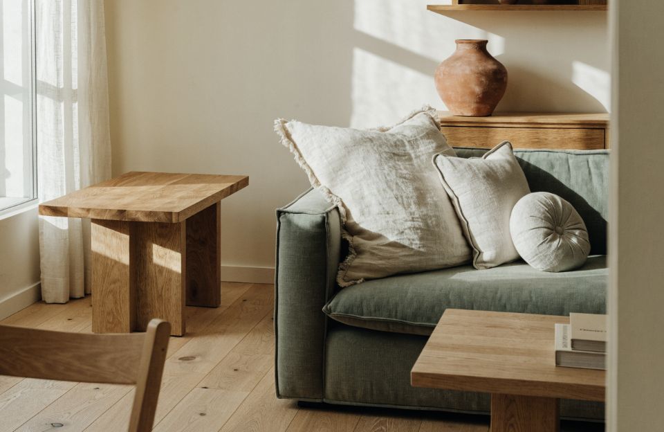 Bright living room with a sage sofa, linen cushions and oak furniture