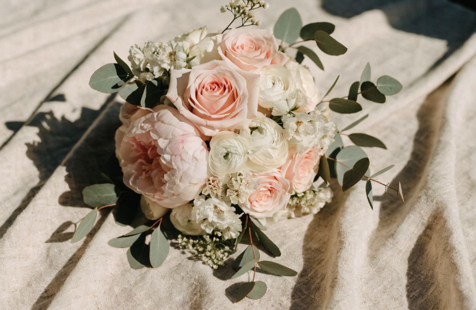 Wedding bouquet with peach roses and eucalyptus on linen
